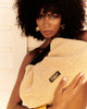 Woman holding a beige textured handbag with a brand logo. My best bag - pouch - woven 