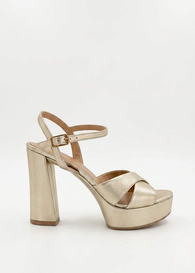 A metallic gold platform sandal with a block heel, open toe, and ankle strap, shown from a side profile on a light gray background.